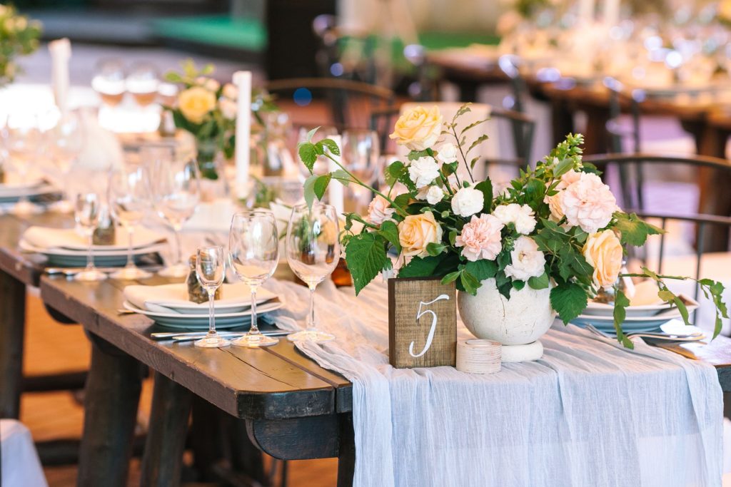 wedding reception center table filled with cutlery and flowers